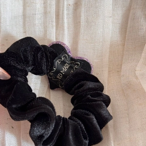 Détail d'un chouchou en velours avec breloque cœur violet et étiquette en satin faite main