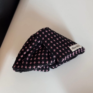 Detail of handmade black hair scrunchie with pink patterns and Hand Made label