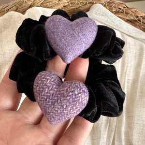 Vue détaillée des chouchous en velours noir avec des breloques cœur violettes texturées