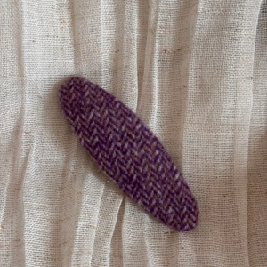 Détail d'une pince à cheveux en tweed violet avec un motif classique à chevrons