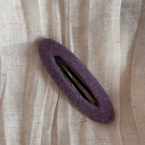 Gros plan sur la texture du tissu tweed violet d'une pince à cheveux vintage