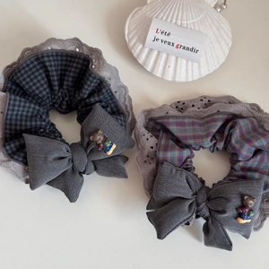 Detail of Korean lace scrunchie with plaid pattern and a cute teddy bear bow decoration