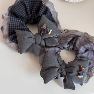Detail of lace scrunchies with plaid patterns, bows, and cute bear charms accessories