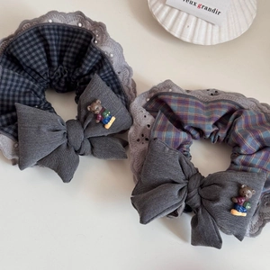 Detail of plaid scrunchies with lace edges, fabric bows, and cute 3D bear ornaments