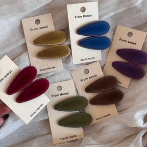 Set of vintage velvet teardrop hair clips in multiple retro colors on display cards