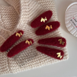 Detail view of red velvet hair clips set featuring vintage golden horse embellishments