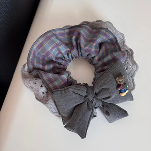 Detail of Korean plaid scrunchie with lace trim, grey bow, and 3D bear ornament