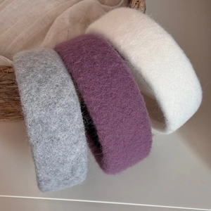 Detailed texture of thick woolen headbands in grey, purple, and white for winter hairstyles
