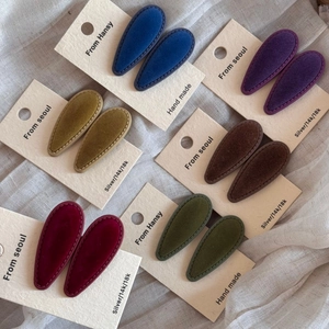 Detail view of 6 pairs of colorful velvet teardrop hair clips on display card