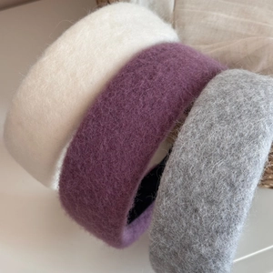 Close-up of thick wool fabric headbands in beige, purple and grey with plush texture