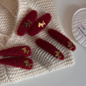 Elegant red wool hair clips set featuring golden horse charms on a knitted background
