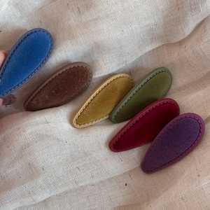 Close-up of six retro velvet water-drop hair clips in muted Morandi colors on linen