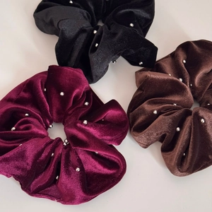 Detail of velvet scrunchies with silver bead accents in red, black, and brown