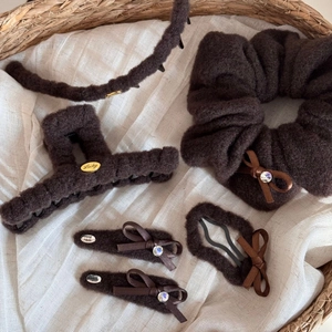 Detail of coffee plush hair accessory set with elegant rhinestone bows and metal Lucky tag