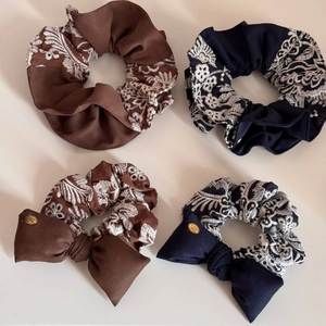 Detailed set of retro knitted hair scrunchies in navy and brown with delicate lace edges