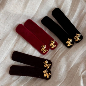 Detailed view of velvet BB clips in red black and brown with golden rhinestone horses