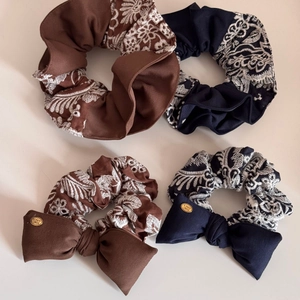 Detailed set of knit scrunchies with floral embroidery and golden bow accents