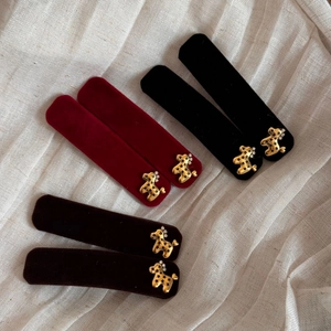 Elegant velvet hair clips with gold bear detail in red, black, and dark coffee brown