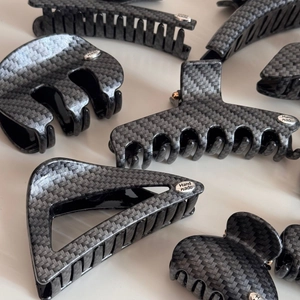 Carbon fiber texture hair claw clips with Hand Made silver labels on white background