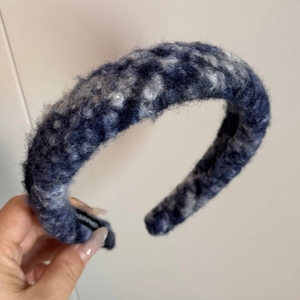 Makroaufnahme des dicken, blau-grau gemischten, plüschigen Stoffes des Stirnbands
