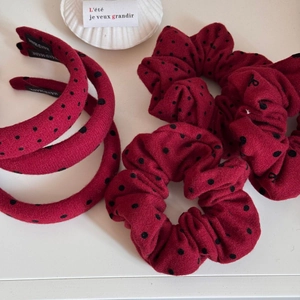 Detailansicht von roten Polka-Dot-Haargummis und Haarbändern mit Handarbeit-Etikett