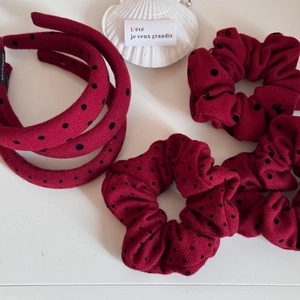 Detail von roten Polka-Dot-Haargummis und Stirnband mit handgefertigtem Etikett auf Weiß