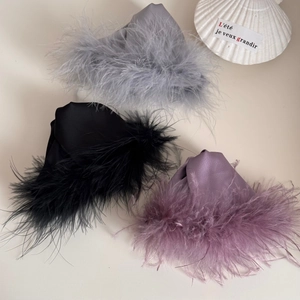 Detail view of plush faux feather hair claws in grey, black, and purple satin finish