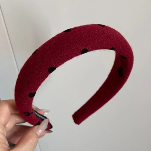 Detailansicht des roten Samt-Stirnbands mit schwarzen Schleifen und rutschfestem Griff