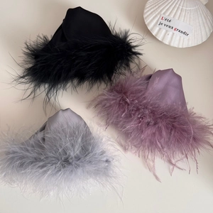 Detailed view of luxury satin hair claws with fluffy feather trim in three elegant colors