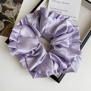 Gros plan sur un grand chouchou en satin violet clair avec détails de froufrous étagés