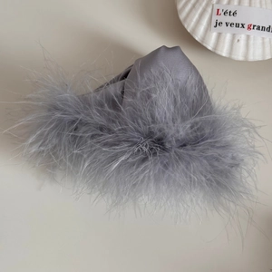 Detail of elegant grey fluffy feather shark hair clip with soft satin finish for women