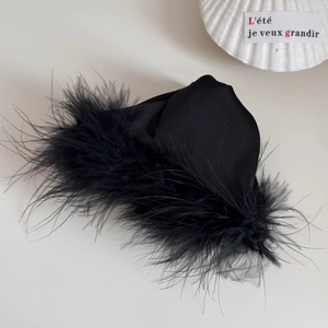 Detailed close-up of luxurious black satin hair claw clip with fluffy ostrich feathers