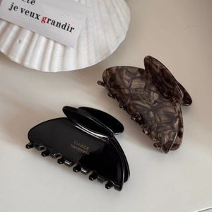 Elegant set of black and tortoiseshell fan-shaped hair claws on minimalist background