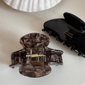 Close-up of tortoiseshell and black fan-shaped hair claws with golden metal springs