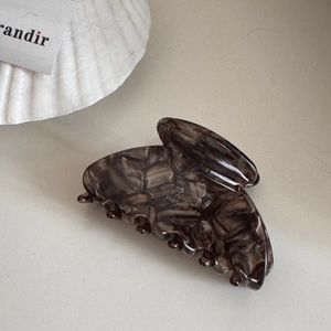 Close-up of handmade tortoiseshell acetate hair claw with FANRCE branding detail
