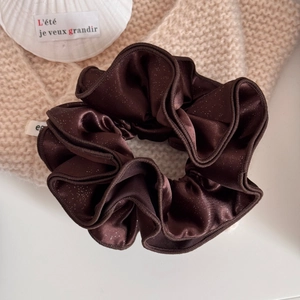 Close-up of large coffee brown satin hair scrunchie with gold glitter and shells