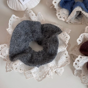 Detailaufnahme von Plüsch-Haargummis mit Spitze in Grau, Blau und Dunkelbraun Tönen
