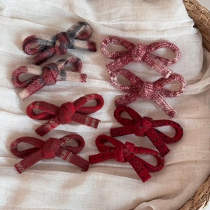 Close-up of 8-piece winter wool bow hair clips with assorted vintage plaid patterns
