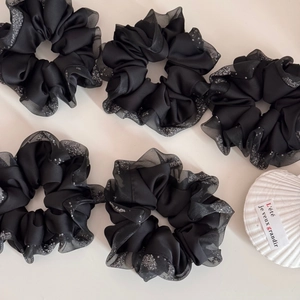 Detail of 5 black satin and organza scrunchies with silver sparkles and French decor