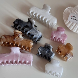 Assorted marble pattern acetate hair claws in various sizes and elegant colors