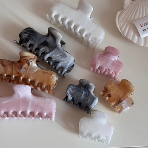 Elegant marble pattern hair claws in various sizes and colors with a French aesthetic
