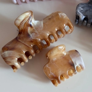 Detail view of acetate medium hair claw clips with elegant ink marble texture