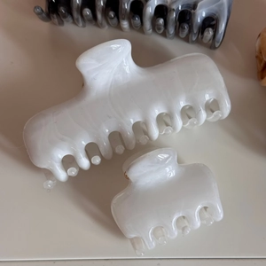 Close-up of marble pattern acetate hair claws in milky white with elegant ink texture