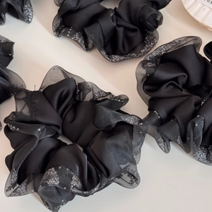 Detail of black satin scrunchie with grey mesh trim and sparkling silver rhinestones