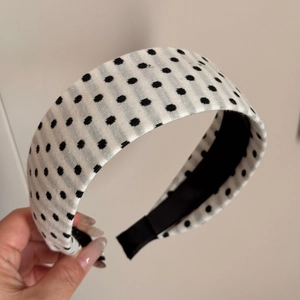 Detailed close-up of wide polka dot fabric headband with non-slip black lining texture