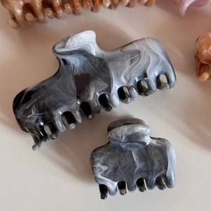 Detail view of marble pattern hair claw clips in black and white acetate finish