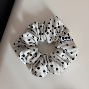 Close-up of polka dot fabric headband featuring a stitched heart label and woven texture