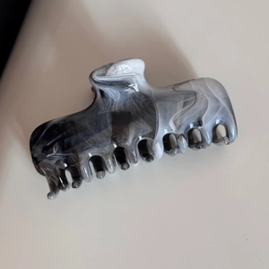 Detailed macro view of the black and white marble ink pattern on the acetate hair claw clip