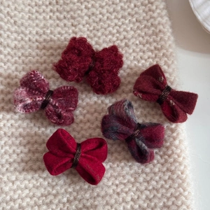 Détails de pinces à cheveux nuds en laine rouge et tweed sur fond en maille beige