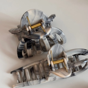 Close-up of ink-wash marble hair clips with strong gold springs in grey and white